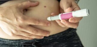 Person administering an insulin injection to their abdomen