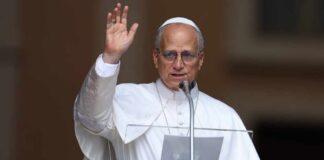 Religious leader giving a speech outdoors with a raised hand