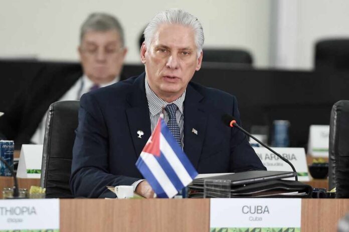 Cuban official speaking at a conference with a flag in front