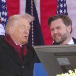 Donald Trump speaking at an outdoor event with a companion