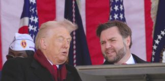 Donald Trump speaking at an outdoor event with a companion