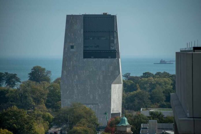 A modern building overlooking a lake with trees in the foreground