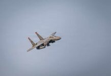 A military fighter jet flying against a clear sky