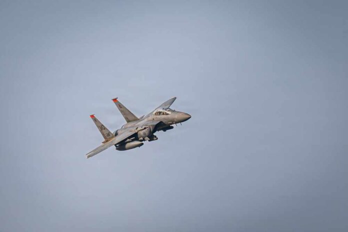 A military fighter jet flying against a clear sky
