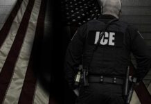 ICE agent standing in front of an American flag