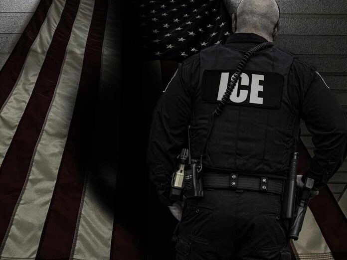 ICE agent standing in front of an American flag