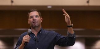 A speaker addressing an audience with a microphone in hand