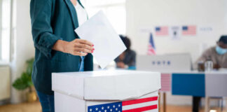 Defense Contractor Scandal Haunts Bronx Candidate A person casting a vote into a ballot box at a polling station