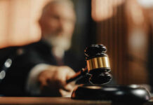 A judge holding a gavel in a courtroom setting