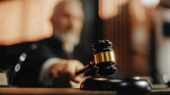 A judge holding a gavel in a courtroom setting