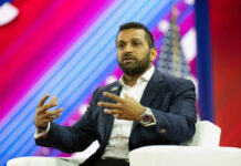 A speaker in a blue blazer passionately discussing on stage at a conference