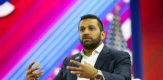 A speaker in a blue blazer passionately discussing on stage at a conference