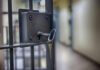 Surge In ICE Suicides: What’s The Real Cause? Close-up of a locked jail cell door with a key inserted