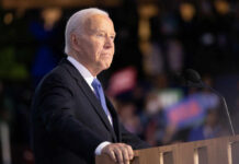 A political leader delivering a speech at a podium with a microphone