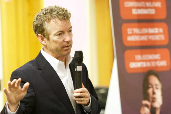 A man in a suit speaking into a microphone during a presentation