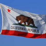 California state flag featuring a bear and a red star against a blue sky
