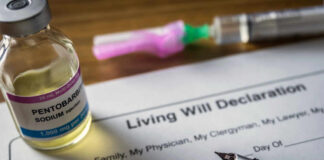A vial of pentobarbital next to a living will declaration form and a fountain pen