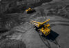 A large yellow dump truck loaded with rocks on a mining site