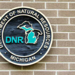 Sign of the Michigan Department of Natural Resources on a brick wall