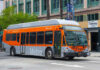 Metro Local bus in orange and silver parked on a city street