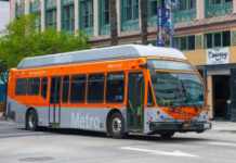 Metro Local bus in orange and silver parked on a city street