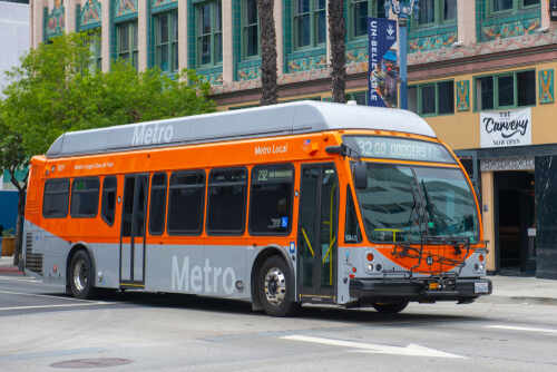 Metro Local bus in orange and silver parked on a city street