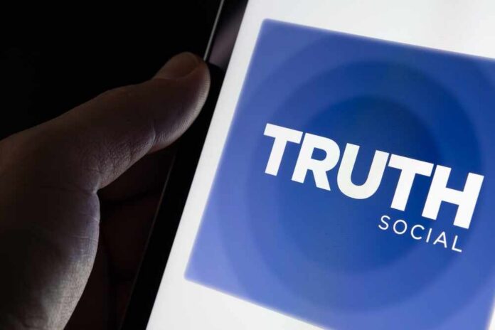 Close-up of a hand holding a smartphone displaying the Truth Social app logo