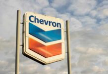 Chevron gas station sign against a cloudy sky