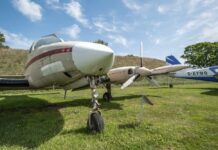 Vintage aircraft parked on a grassy field under a blue sky