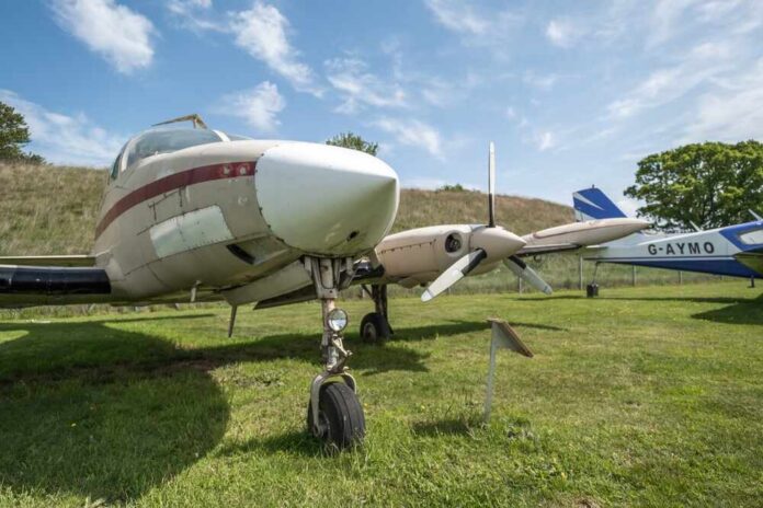 Vintage aircraft parked on a grassy field under a blue sky