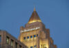 The top of a building featuring the sign of The Washington Post against a blue evening sky