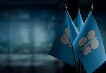 Three blue flags with a silver emblem on a blurred background