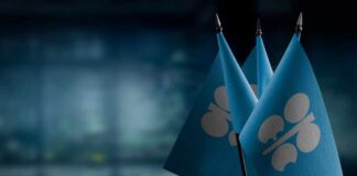 Three blue flags with a silver emblem on a blurred background