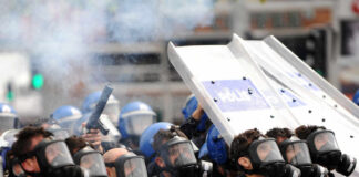 Leadership Clash SPARKS Violent Police Raid Riot police in gas masks with shields amid smoke