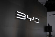 Illuminated BYD logo on a dark wall