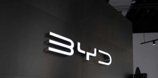 Illuminated BYD logo on a dark wall
