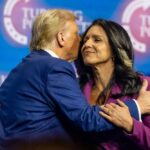 Two public figures embracing at a political conference