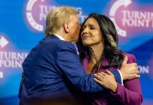 Two public figures embracing at a political conference