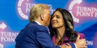 Two public figures embracing at a political conference