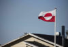Massive Anti-US Protests Erupt in Greenland! Flag of Greenland waving in the wind above a house