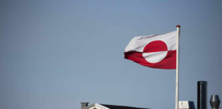 Massive Anti-US Protests Erupt in Greenland! Flag of Greenland waving in the wind above a house