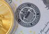 Probe Twist: New Fed Governor Confirmed Close-up of a gold coin next to a US dollar bill