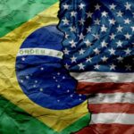 Brazil and United States flags split by a jagged tear
