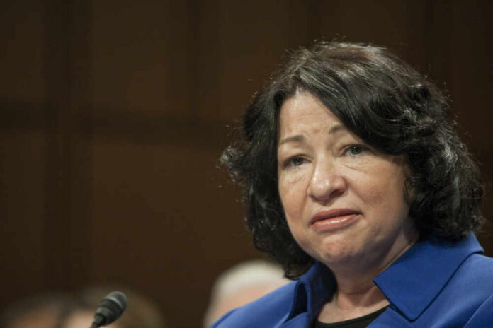 A woman in a blue blazer speaking during a formal hearing