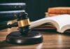 Judge's gavel on desk with open law book