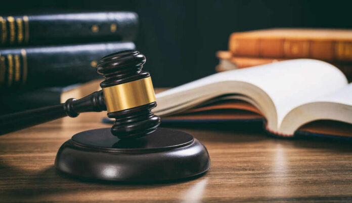Judge's gavel on desk with open law book