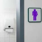 Unisex restroom sign on a white wall