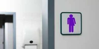 Unisex restroom sign on a white wall