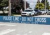 Crowd Ambushed—City Demands Accountability Yellow police caution tape at a crime scene with blurred figures in the background