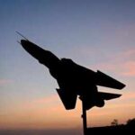 Airspace Nerve-Game Escalates Near Korea Silhouette of a fighter jet mounted on a pedestal at sunset